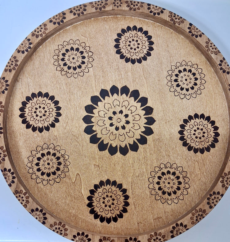 Close-up of hand wood-burned mandala floral pattern on round wood serving tray