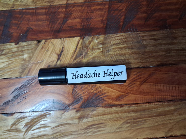 Dark roll-on bottle with a black cap and white label lying horizontally on a wood-grain surface